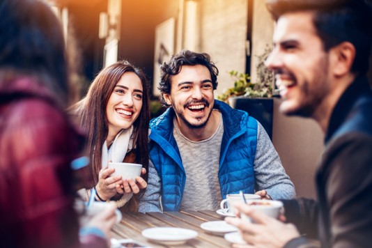 group of friends gathered around a table drinking coffee