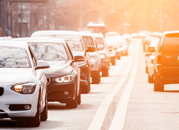 Several cars driving down a street in traffic